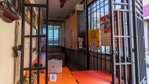 A room with a desk, a laptop, and a mobile phone on a table. There are posters on the wall and a calendar. - Puducherry Residency (Puducherry)