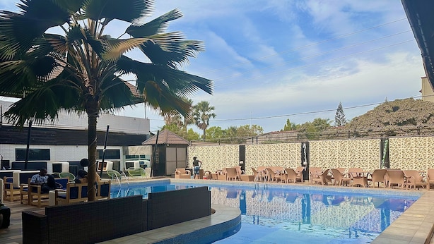 Ein Swimmingpool mit Liegestühlen und einer Palme.