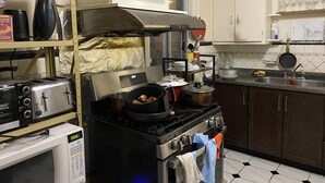 Una cocina equipada con estufa, microondas, tostadora y diversos utensilios.