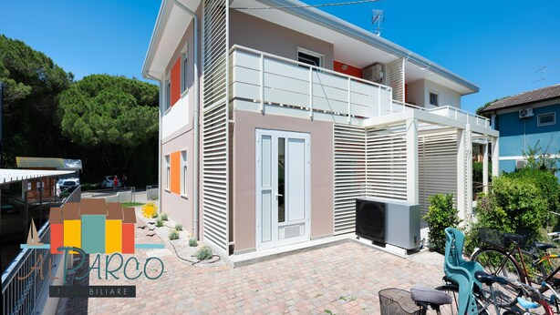 Ein zweistöckiges Haus mit Balkon, Garage und befestigter Auffahrt.