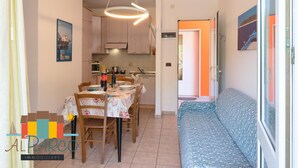 Uma cozinha compacta com armários de madeira, uma mesa de jantar com cadeiras e um banco embutido.