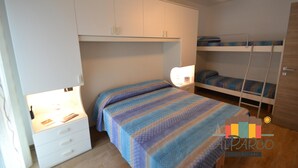 A compact bedroom with a bunk bed, a bedside table with a lamp, and a wardrobe. - Apartment with 1 bedroom near to the beach LP 16 (Rosolina Mare)