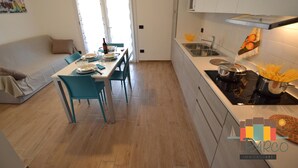 Eine moderne Küche mit Essbereich, einer Couch und einem fensterbehangenen Fenster.