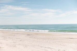 A beach with a wide sandy shore and gentle waves. - Water Views with Pool and Beach Access! (Topsail Beach)