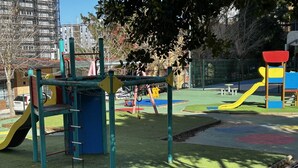 Ein Spielplatz mit Klettergerüsten, Rutschen und einem umzäunten Bereich.