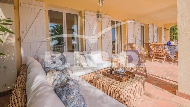 A sunlit patio with a wicker sofa, wicker chairs, and a table set for dining. - Provençal villa with sea view (STE MAXIME)