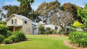 A two-story house with a front yard and a garden. - Wisteria Vines Estate—Rustic Elegance by the Coast (Wilyabrup)