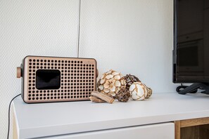 A white desk with a laptop, a speaker, and decorative items.