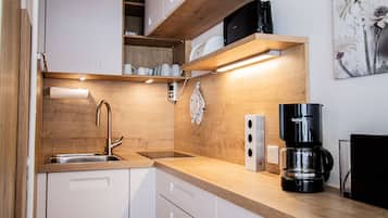 Een koelkast, een oven, een kookplaat, een koffiezetapparaat/waterkoker