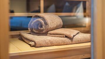 Een houten bank met opgerolde handdoeken.