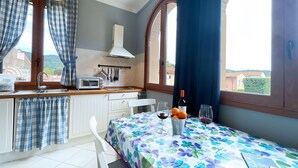 Una piccola cucina con un tostapane, un lavello e una finestra che dà su una zona residenziale.