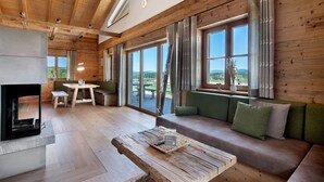 Un interior de madera con sofá, mesa y chimenea.