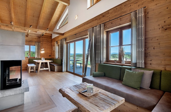 A wooden interior with a sofa, table, and fireplace.
