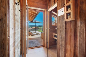 A wooden interior with a glass door leading to an outdoor deck with a view of the countryside. - Chalet 'Bergchalet 1' with Private Pool, Private Terrace and Wi-Fi (Freyung)