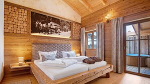 A wooden-framed bed with a headboard, a nightstand, a wall-mounted picture, and a large window with curtains. - Chalet 'Bergchalet 1' with Private Pool, Private Terrace and Wi-Fi (Freyung)