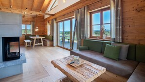 A wooden interior with a sofa, a table, and a fireplace. - Chalet 'Bergchalet 1' with Private Pool, Private Terrace and Wi-Fi (Freyung)