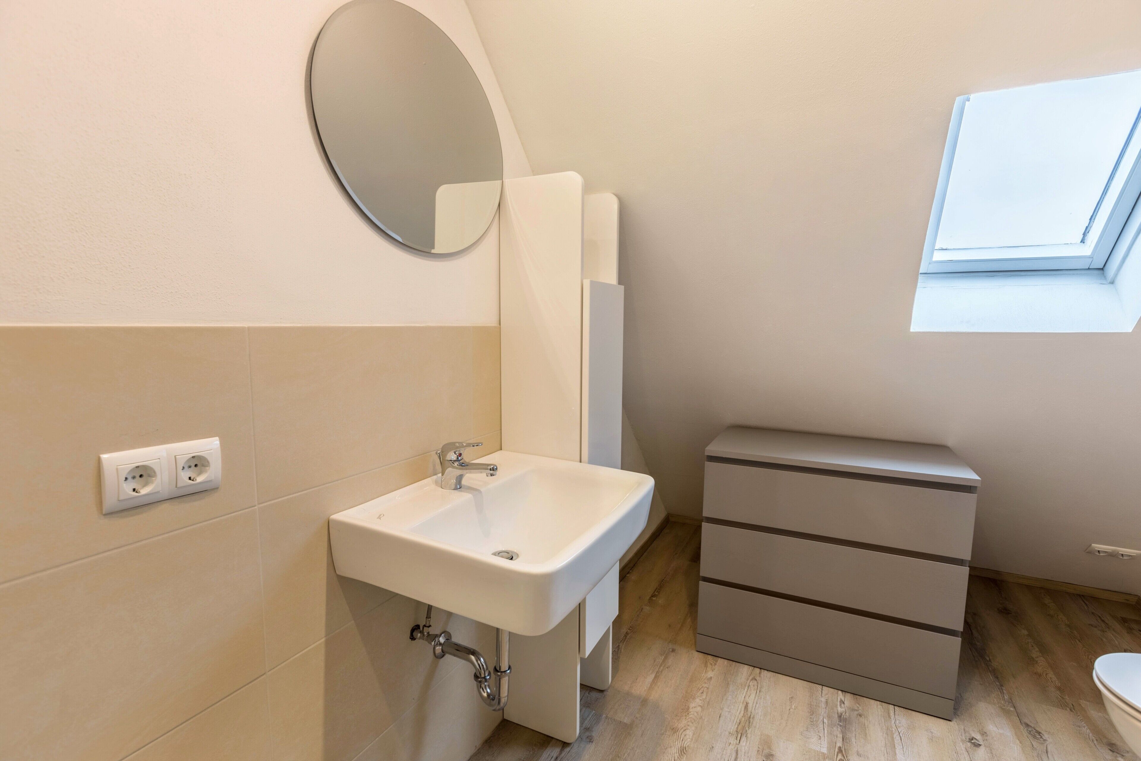 Ein Badezimmer mit Waschbecken, Spiegel und Fenster.
