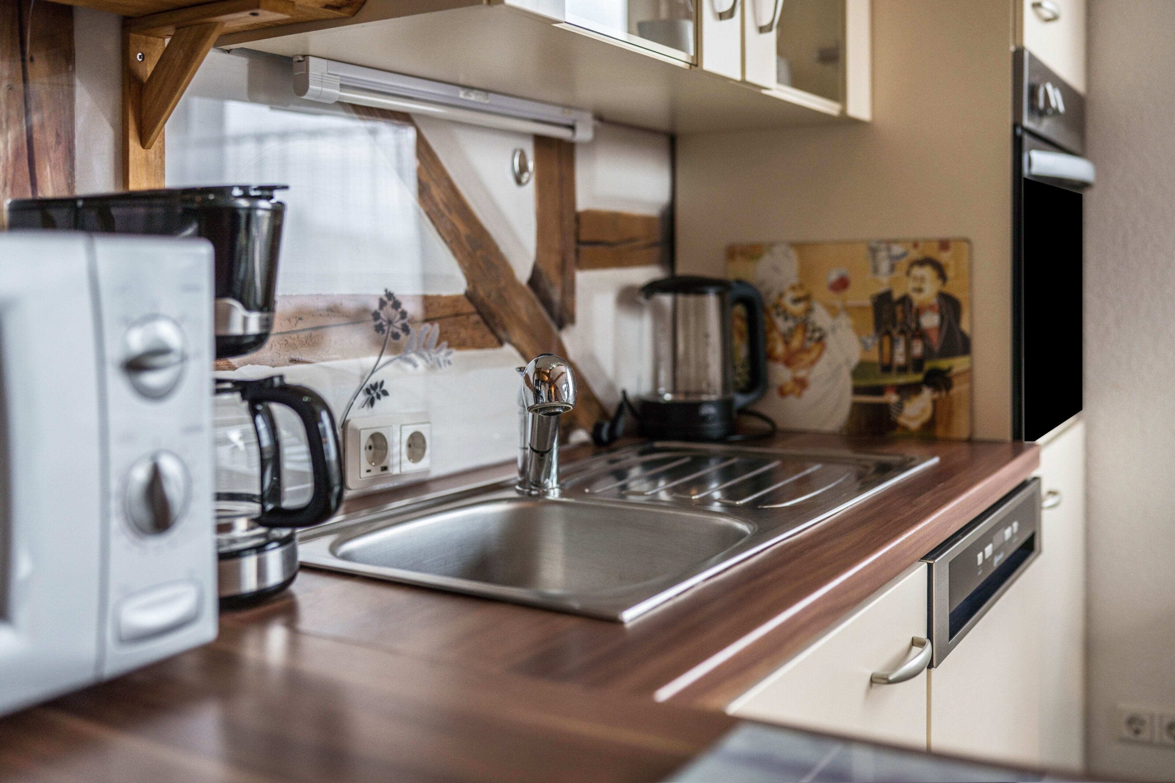 A kitchen with a stainless steel sink, a coffee maker, and a dishwasher.