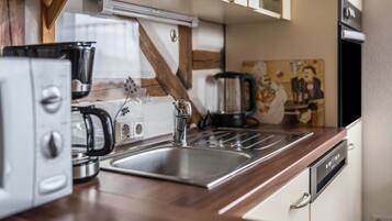 A kitchen with a stainless steel sink, a coffee maker, and a dishwasher.