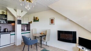 Una cocina moderna con comedor, televisión de pantalla plana y chimenea.