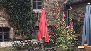 A courtyard with stone flooring, outdoor seating, and a building with exposed timber framing. - Holiday flat "Kemenate" - individual flat under the roof (Trendelburg)