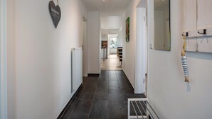 Ein Flur mit Herzdekoration, Heizkörper, Abtropfbrett und Spiegel an der Wand.