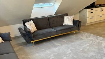 Ein modernes Schlafzimmer im Loft-Stil mit einer Couch, einem Essbereich und einem Oberlicht.