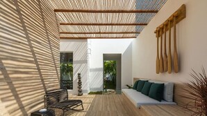 Ein modernes Interieur mit einer Holzbank, einem Sofa und einer an der Wand befestigten Holzskulptur.