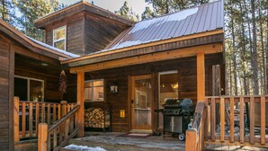 A wooden cabin with a porch, steps leading to the entrance, and a grill outside. - Memory Mtn Lodge by Velo (Angel Fire)