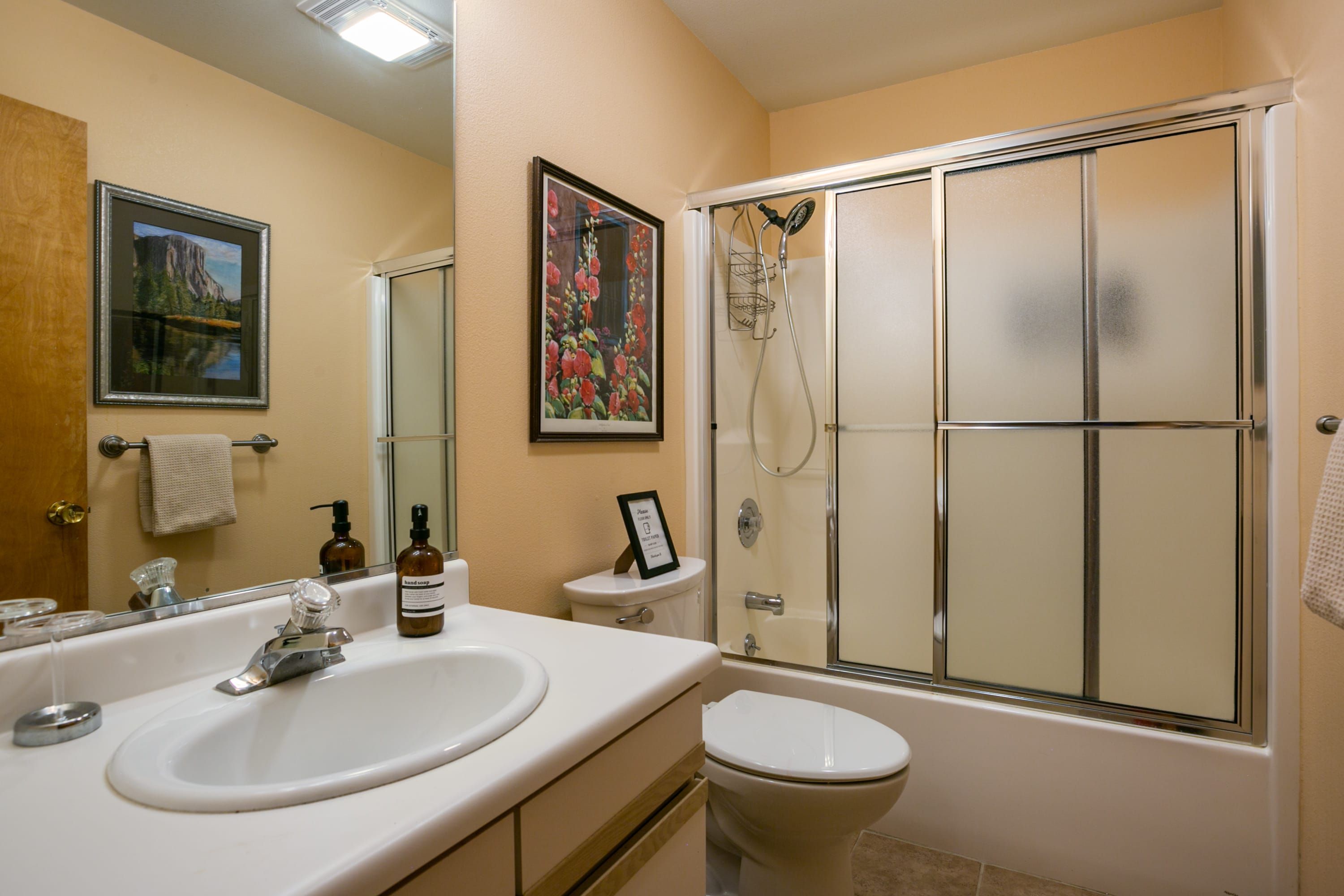 A bathroom with a sink, toilet, and shower.