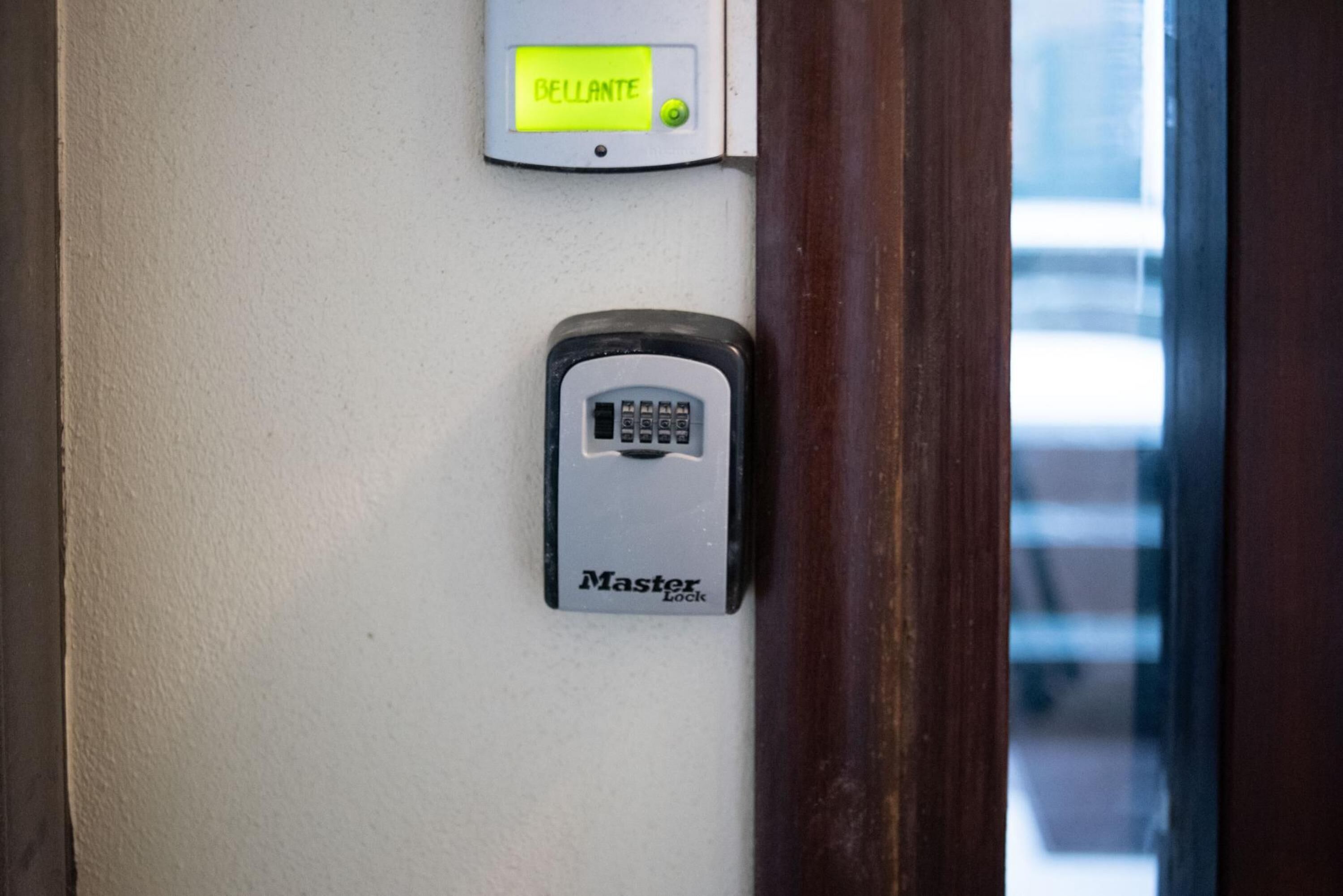 Una puerta con cerradura digital y un panel de control con la etiqueta 'Bellante'.