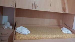 Ein Einzelbett mit einem gemusterten Matratze und zwei darauf gefalteten Handtüchern.