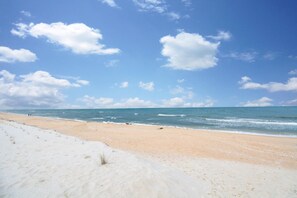 Ein Strand mit blauem Himmel und ruhiger See.