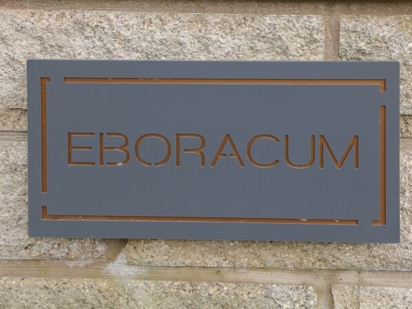 A sign with the word "EBORACUM" on a stone wall. - Eboracum (Hope Valley)