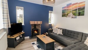 A modern living room with a fireplace, a sofa, a coffee table, and a television. - Eboracum (Hope Valley)