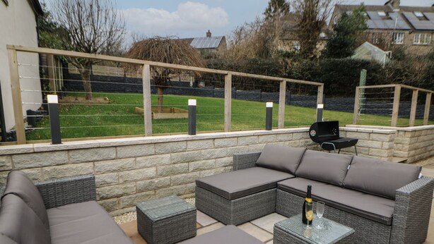 An outdoor patio with a sectional sofa, a small table, and a grill. - Eboracum (Hope Valley)