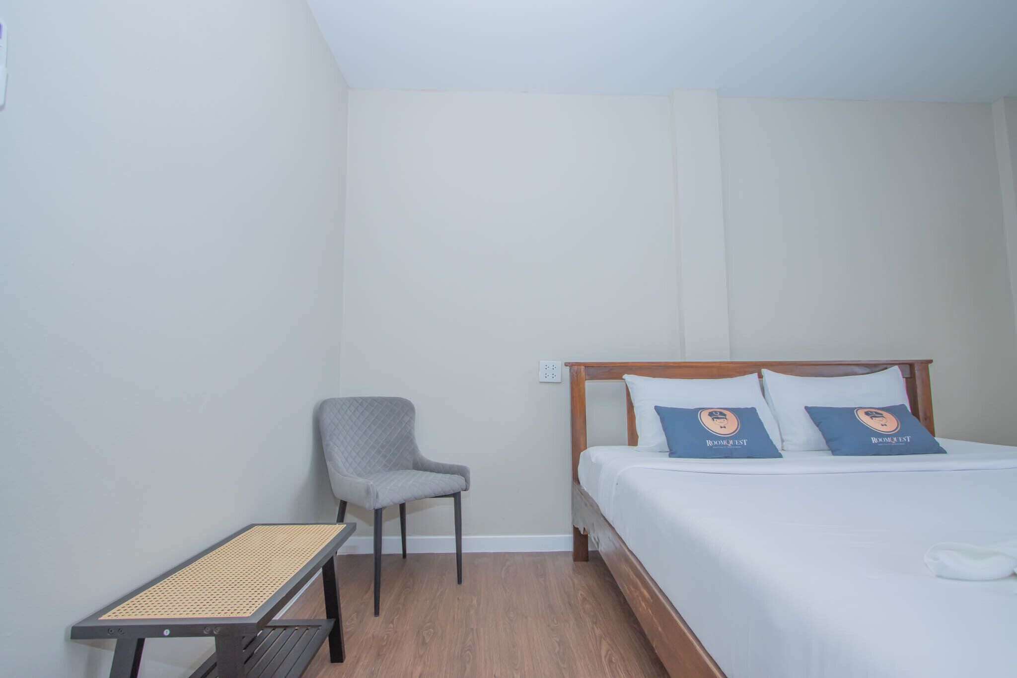 A hotel room with a bed, a chair, and a small table.