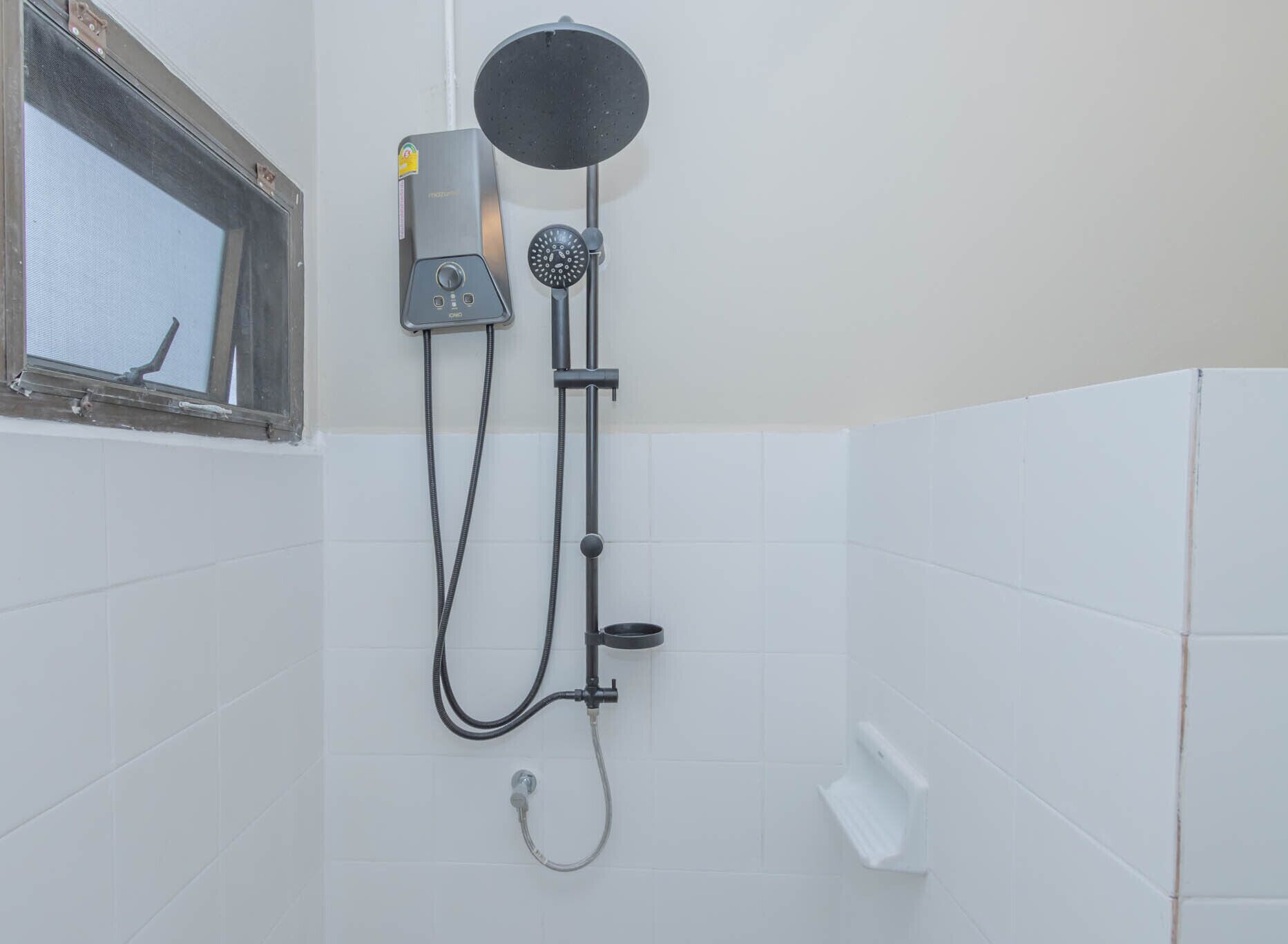A shower with a handheld showerhead, a wall-mounted control panel, and a window with a view.