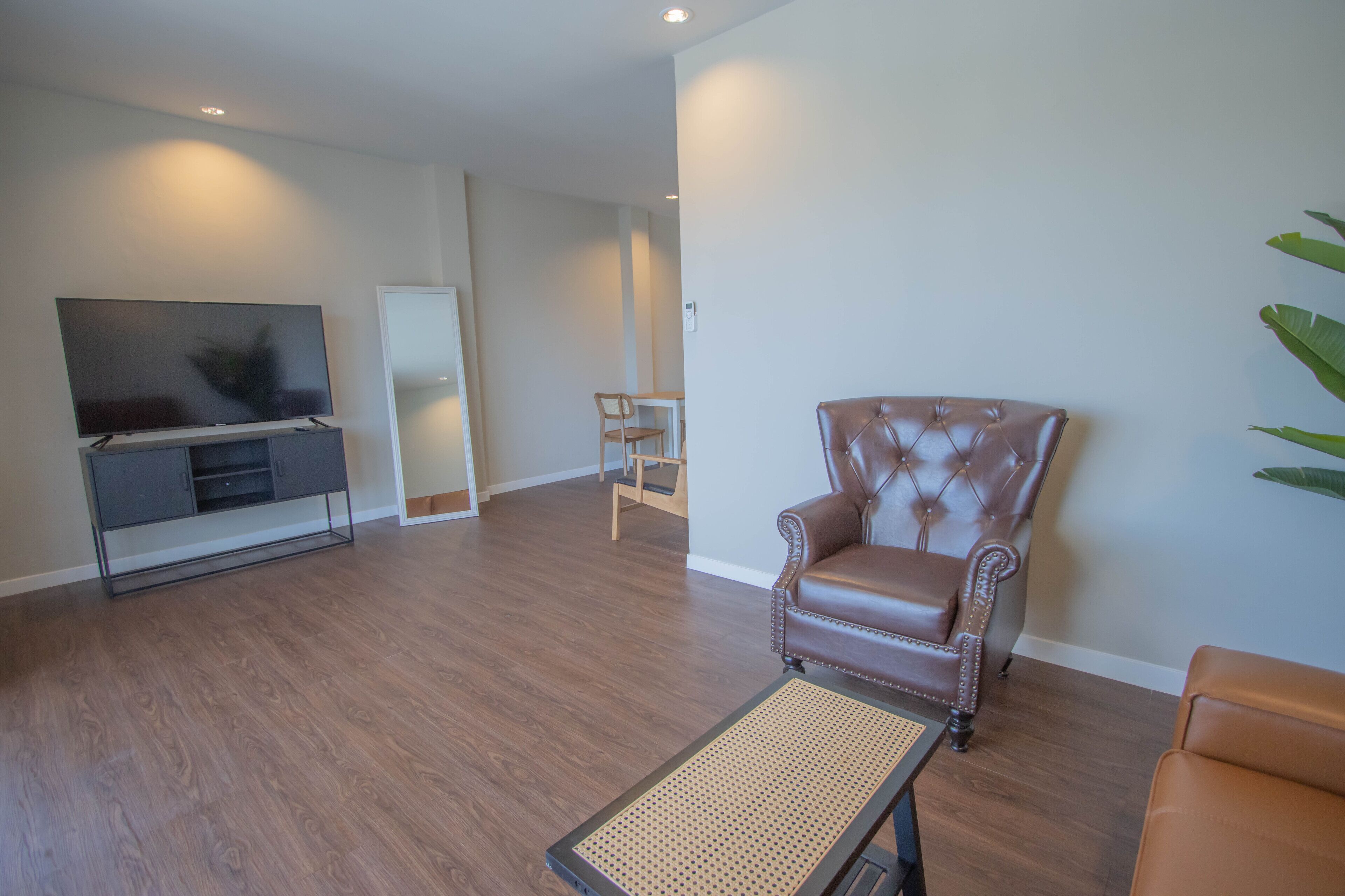 A living room with a leather armchair, a television, and a small table.