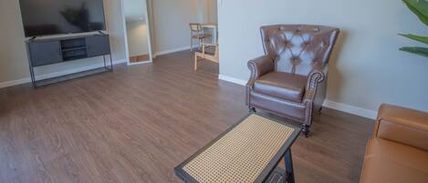 A living room with a leather armchair, a television, and a small table.
