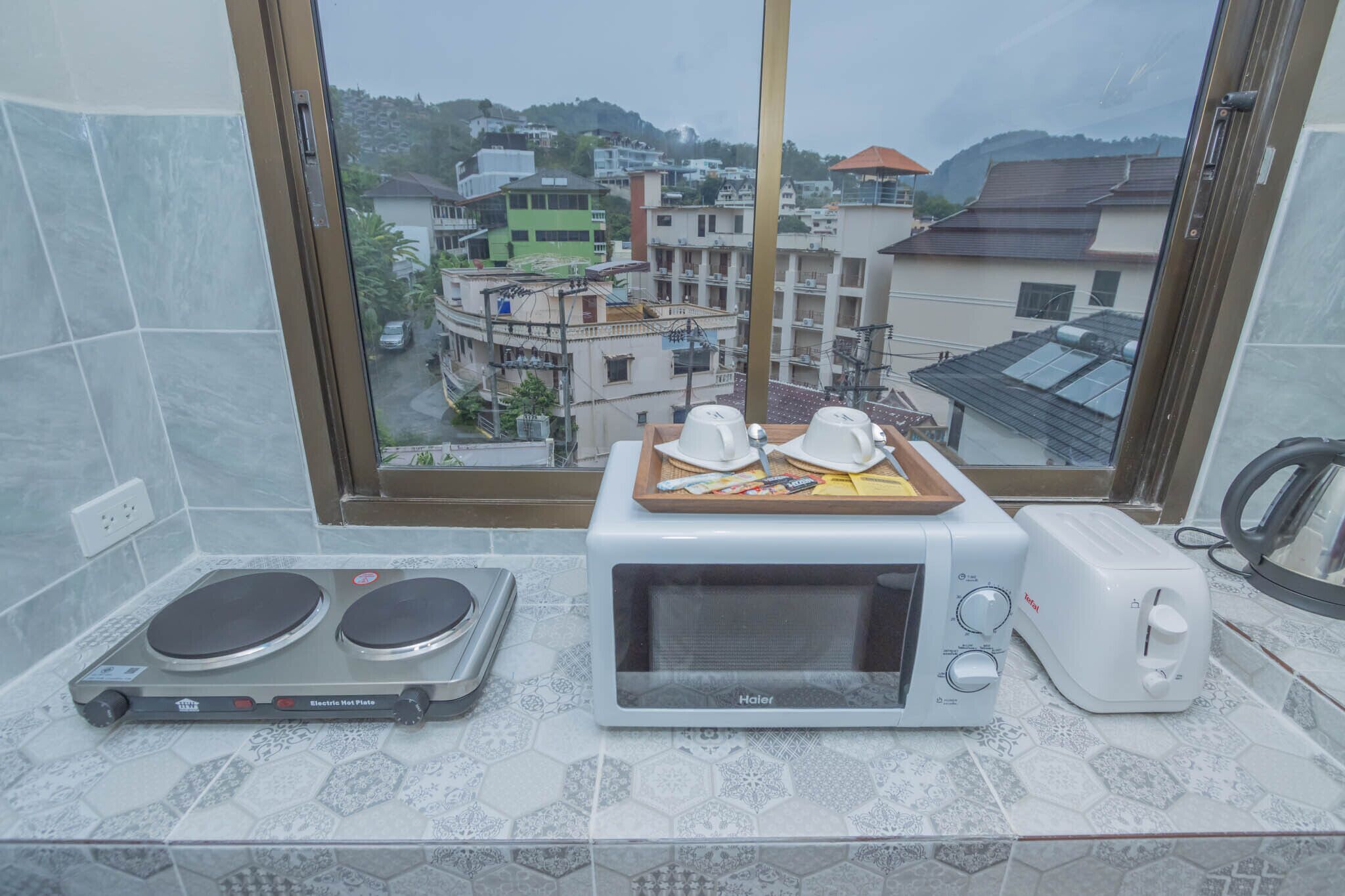 Une cuisine équipée d’un four à micro-ondes, d’un grille-pain et d’une plaque de cuisson électrique.