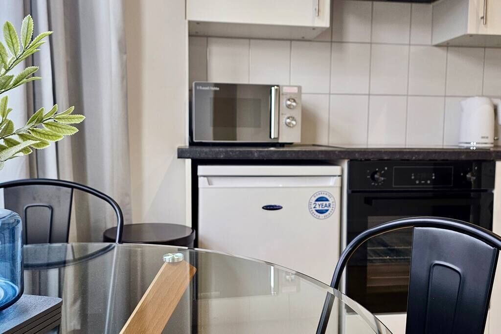 A compact kitchen with a microwave, a small refrigerator, and a coffee maker.