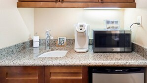A kitchen with a granite countertop, a coffee maker, a microwave, and a dishwasher. - Serene Studio in the Resort-Style Legacy Villas Complex (La Quinta)