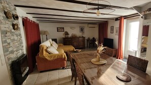 A dining area with a wooden table, chairs, and a central vase with dried flowers. - Charmant Gîte 3 Cosy, Climatisé, Environnement Bucolique, en Périgord Noir (Sagelat)