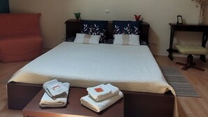 A bedroom with a skylight, a bed with a white bedspread, a wooden bench, and a small table with a plant. - Charmant Gîte 3 Cosy, Climatisé, Environnement Bucolique, en Périgord Noir (Sagelat)
