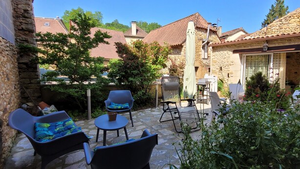 A stone building with a patio area featuring outdoor furniture and a grill. - Charmant Gîte 3 Cosy, Climatisé, Environnement Bucolique, en Périgord Noir (Sagelat)