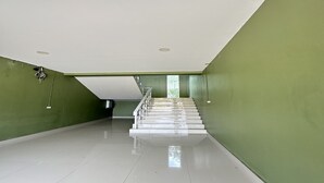A spacious, empty room with a staircase leading to another level. - OYO 75467 Baan Siripornchai 2 (Sakon Nakhon)