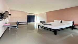 A hotel room with a bed, a desk with a computer, and a chair. - OYO 75467 Baan Siripornchai 2 (Sakon Nakhon)