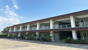 A two-story building with a balcony on the upper floor, potted plants, and a sign indicating room B. - OYO 75467 Baan Siripornchai 2 (Sakon Nakhon)