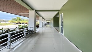 A corridor with a tiled floor, white railings, and green walls. - OYO 75467 Baan Siripornchai 2 (Sakon Nakhon)